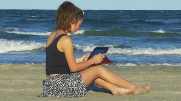 Woman chatting on social media on tablet pc by the sea - 映像、動画