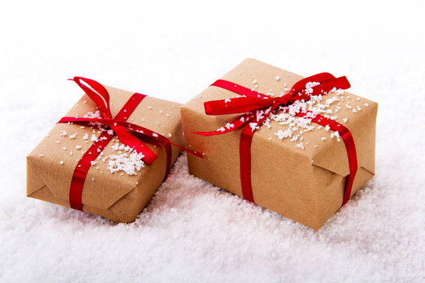 Christmas presents in brown paper with red ribbon - Photo, Image