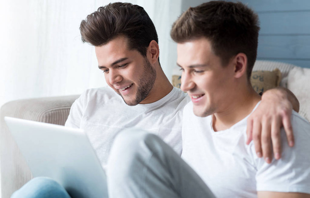 Emotional homosexual couple using laptop. - Photo, Image
