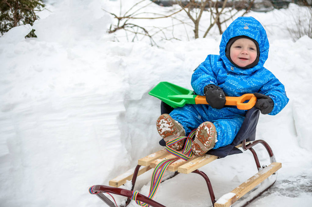 Bambino scorrevole con slittino sulla neve
 - Foto, immagini