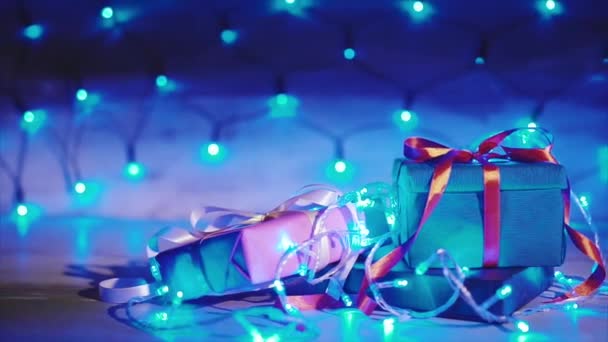 Κοντινό πλάνο της χριστουγεννιάτικο δώρο κουτιά με γαλάζια γιρλάντα - Πλάνα, βίντεο