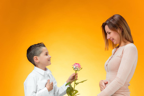 Young kid giving red rose to his mom - Foto, Bild