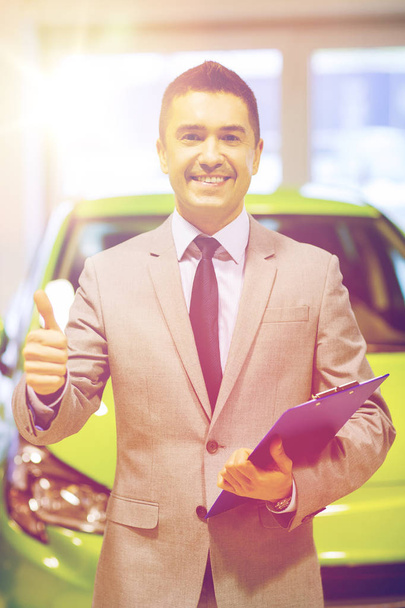 man showing thumbs up at auto show or car salon - Фото, зображення
