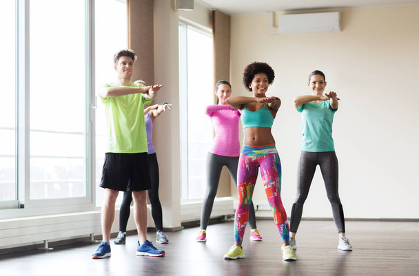 group of smiling people dancing in gym or studio - Photo, Image