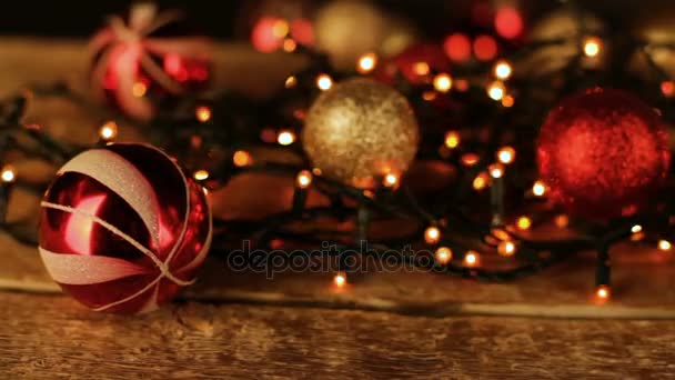 Kerstdecoratie met ballen en lampjes op houten tafel. - Video
