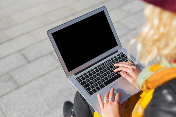 Mujer sentada afuera y usando computadora portátil
 - Foto, Imagen