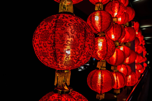 Chinese traditional ball-shaped lantern shining in the night on the background of the lanterns (Singapore) - Photo, Image