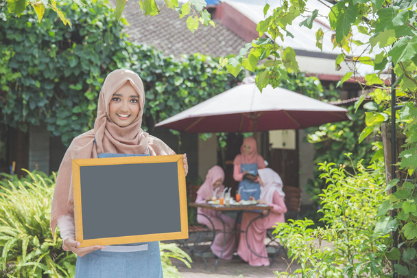 Asian waitress holding blank chalkboard - Foto, imagen