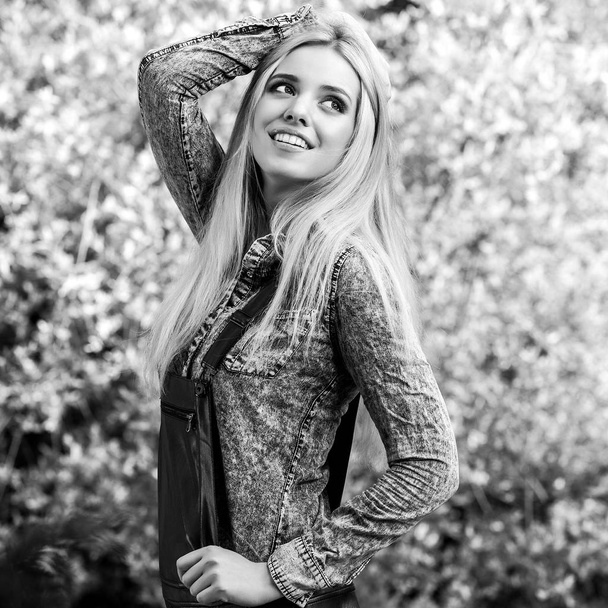 Black-white outdoor portrait of beautiful young smiling blond woman. - Fotó, kép