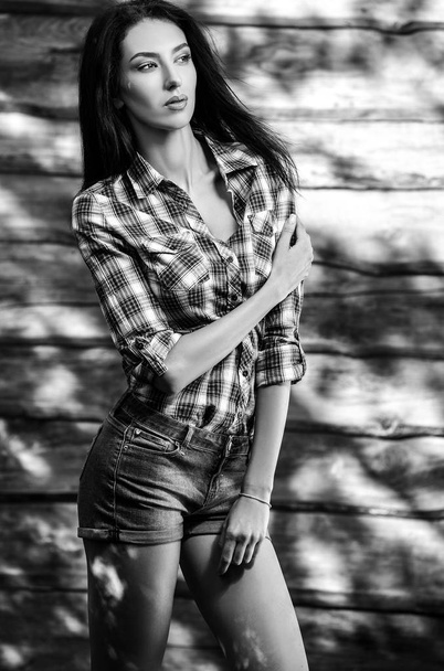 Young sensual & beauty brunette woman pose against wooden background. Black-white photo. - Фото, зображення
