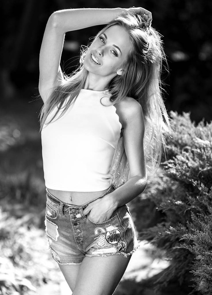 Black-white outdoor portrait of beautiful young sexual blonde woman against nature background. - 写真・画像