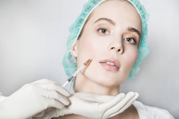 Doctor aesthetician makes face beauty injections to female patient - Фото, зображення
