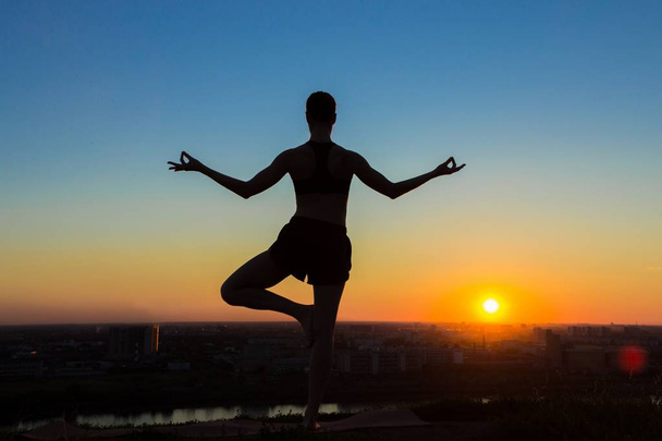 Gün batımında pratik Yoga parkta kadın - Fotoğraf, Görsel