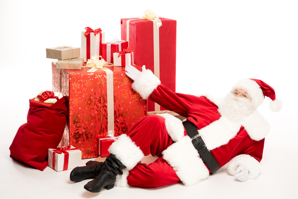 Santa Claus cerca de la pila de regalos de Navidad
 - Foto, imagen