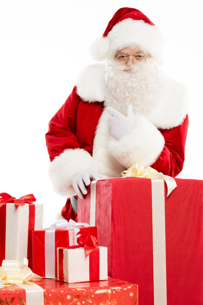 Santa Claus with pile of Christmas gifts - Фото, изображение
