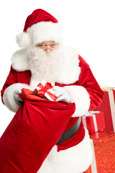 Weihnachtsmann holt Weihnachtsgeschenk aus Sack - Foto, Bild