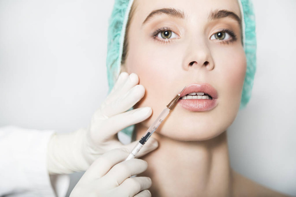 Doctor aesthetician makes lips correction and augmentation to female patient - Foto, Imagem