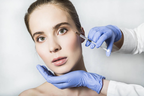 Doctor aesthetician makes face beauty injections to female patient - Foto, Bild