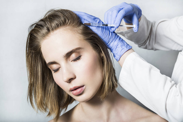 Doctor aesthetician makes head beauty injections to beautiful female patient - Zdjęcie, obraz