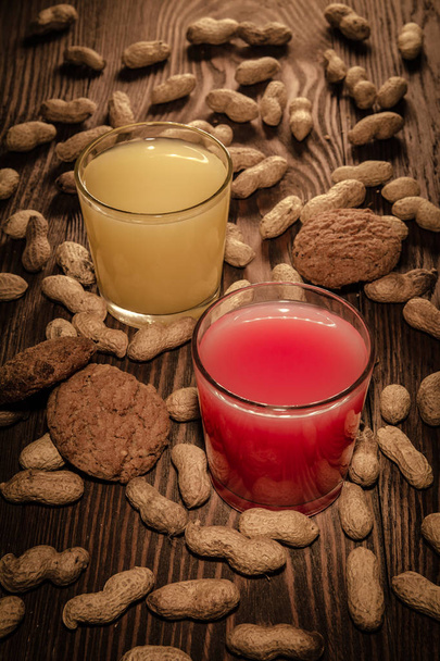 oatmeal cookies and juice in a glass on a wooden background with nuts - Фото, зображення