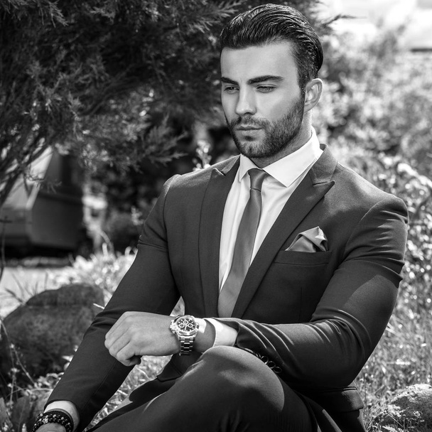 Black-white outdoor portrait of elegant handsome man in classical suit. - Zdjęcie, obraz