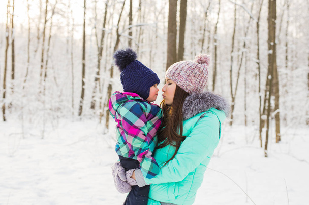 mladá brunetka matka s její dcerou venku. zimní čas - Fotografie, Obrázek