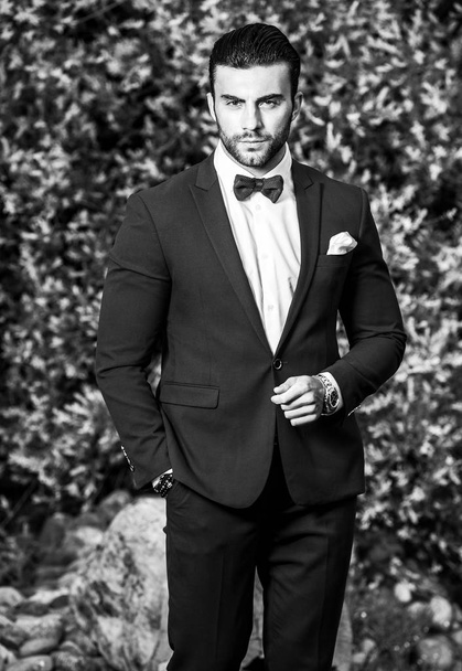 Black-white outdoor portrait of elegant handsome man in classical suit. - Foto, Imagen