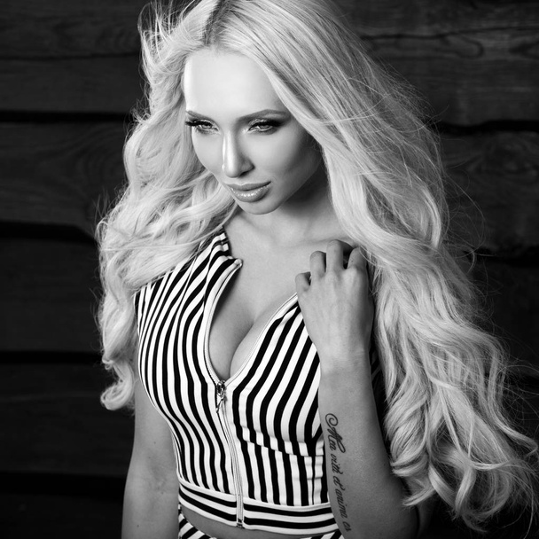 Young sensual & beauty blonde woman pose on wooden background. Black-white photo. - Foto, Imagen