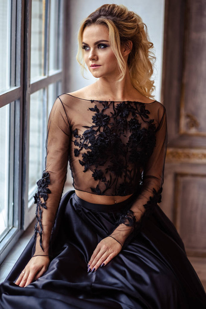 Beautiful young woman in gorgeous black evening dress with perfect makeup and hair style - Foto, immagini