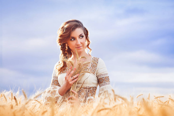 Hezká žena oblečená v Vyšívané šaty v pšeničné pole - Fotografie, Obrázek