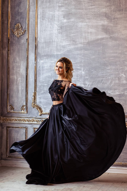 Beautiful young woman in gorgeous black evening dress with perfect makeup and hair style - 写真・画像