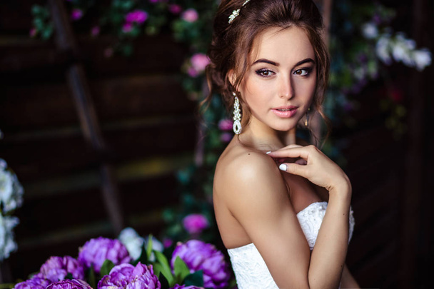 Gorgeous bride young woman in a wedding dress with perfect makeup and hairstyle - Фото, зображення