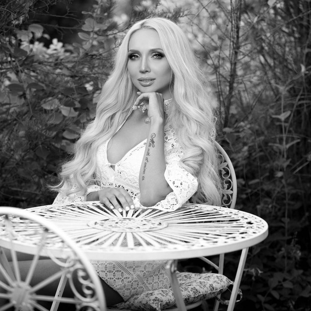 Black-white outdoor portrait of beautiful young blond woman in stylish dress. - Zdjęcie, obraz