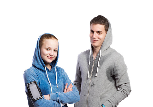Teenage boy and girl in sweatshirts. Studio shot, isolated. - 写真・画像