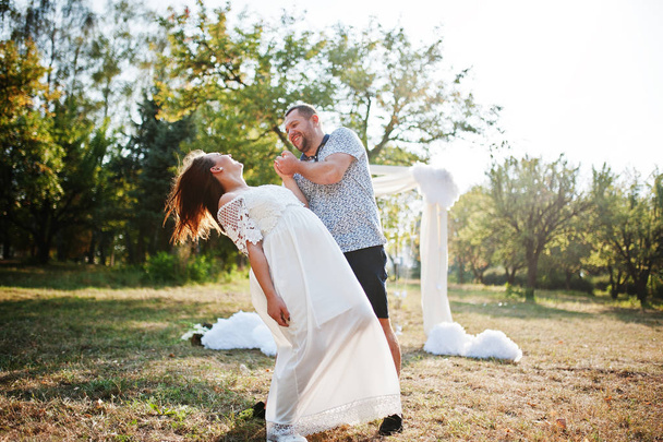 Happy pregnant couple stay hugging and loving near decor arch at - Foto, afbeelding