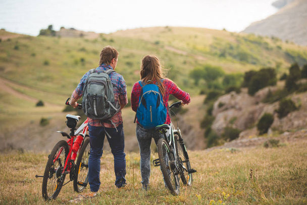 fiatal pár, lovaglás kerékpárok a hegyekben - Fotó, kép