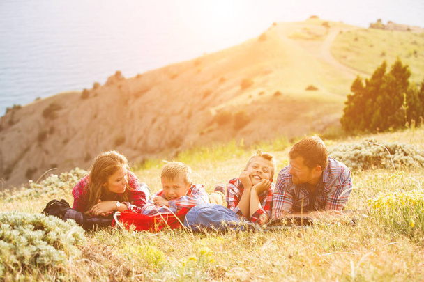 Family of four people looking to beautiful seascape in mountains - Foto, afbeelding