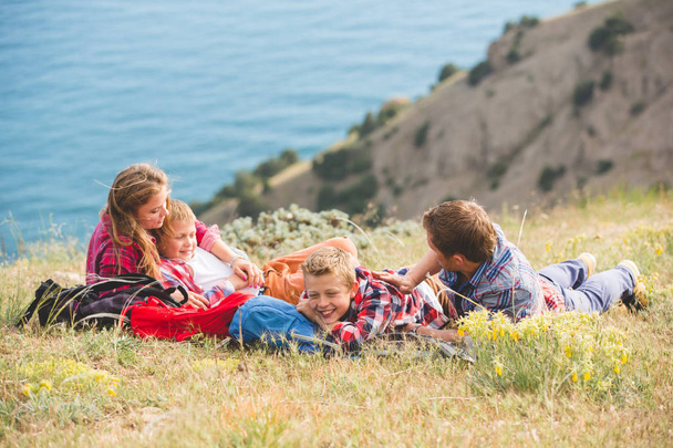 Family of four people looking to beautiful seascape in mountains - Photo, image