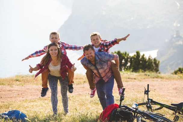 Neljän hengen perhe pyöräilemässä vuorilla
 - Valokuva, kuva