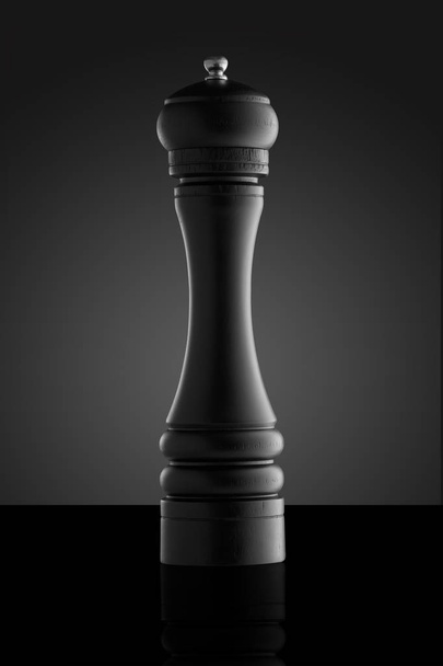 Fekete bors grinder elszigetelt fekete háttér - Fotó, kép