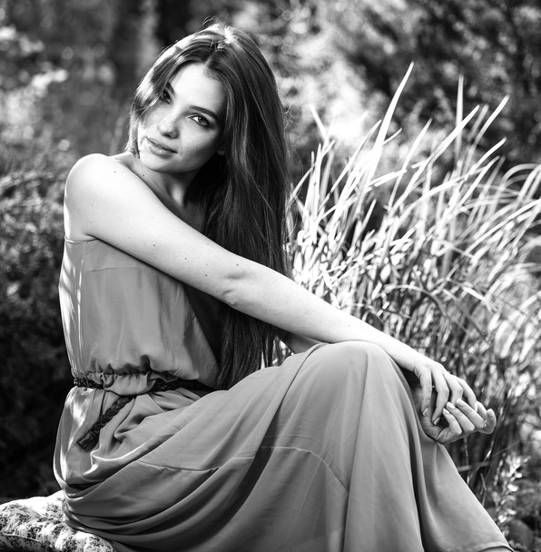 Black-white outdoor portrait of beautiful emotional young brunette woman in stylish dress - Fotó, kép