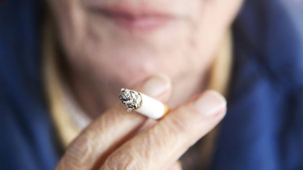 closeup of older woman holding a cigarette - Photo, Image