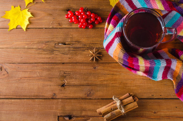 Sonbahar dekorasyonu: bir fincan çay, baharat ve yün atkı, üstten görünüm. - Fotoğraf, Görsel