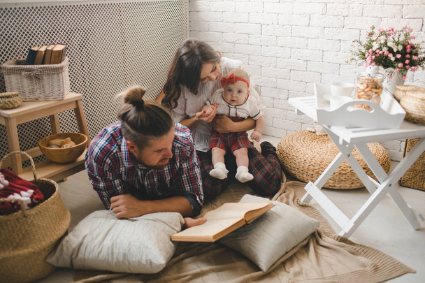 Young family reading story indoors - Foto, Imagem