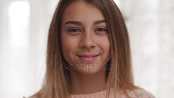 young girl looking at the camera and smilling, beautiful face - Video, Çekim
