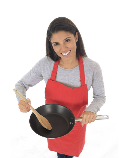 retrato corporativo de joven atractiva cocinera hispana casera en delantal rojo posando feliz y sonriente aislado
 - Foto, Imagen
