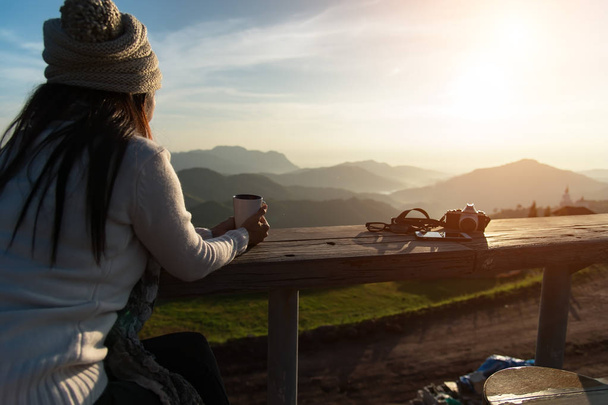 Mulher bebendo café ao sol sentado ao ar livre em luz do sol desfrutando de seu café da manhã, vintage, suave e selecione o foco
 - Foto, Imagem