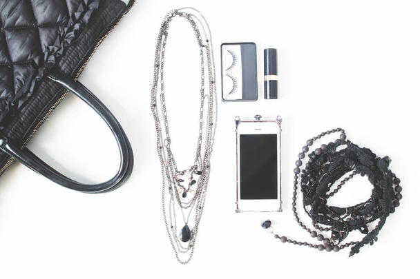 Płaskie ukształtowanie pusty notebook, telefon i akcesoria kobiety w czarnych koncepcja, widok z góry, na białym tle - Zdjęcie, obraz