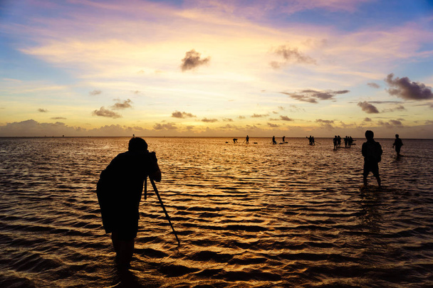 El fotógrafo está tomando una foto en la playa al amanecer en el Delta del Mekong, Bac Lieu, Vietnam
 - Foto, Imagen