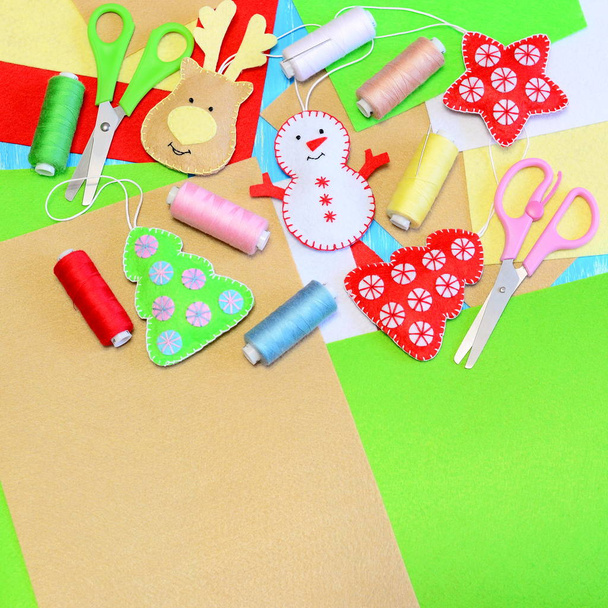 Christmas tree ornaments crafts. Felt Christmas tree, star, snowman, deer crafts, colored thread set, felt sheets, needles, scissors. Funny kids Christmas background with copy space for text. Top view  - Photo, Image